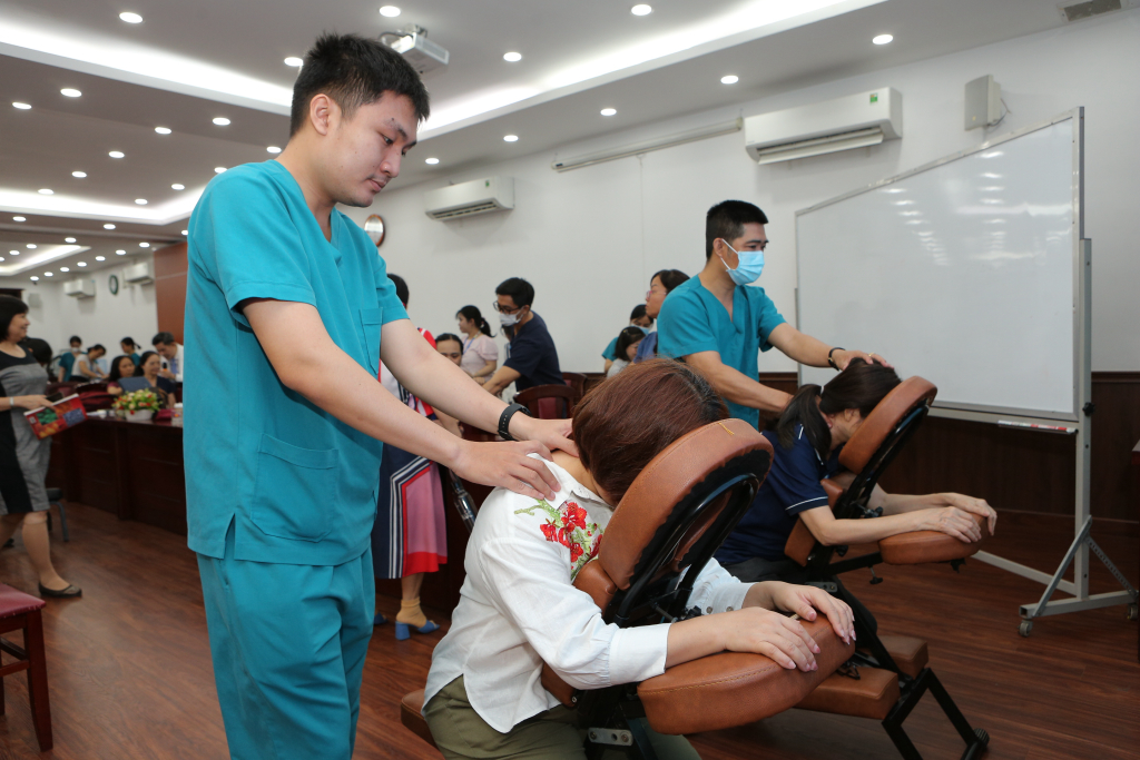 Người tham gia trải nghiệm phương pháp trị liệu bấm huyệt, xoa bóp dưới sự hỗ trợ của các bác sĩ - Ảnh: NGHI CHÂU