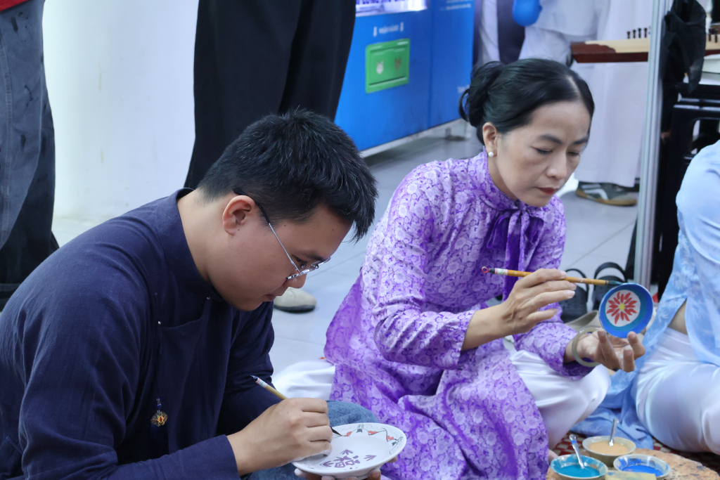 Khách tham gia trải nghiệm vẽ trên bát, dĩa - Ảnh: ĐỨC ÂN