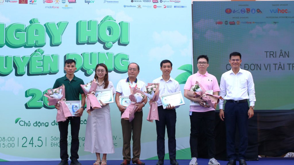 Đại diện Nhà trường tặng hoa cho các doanh nghiệp đối tác - Ảnh: Thu Hương