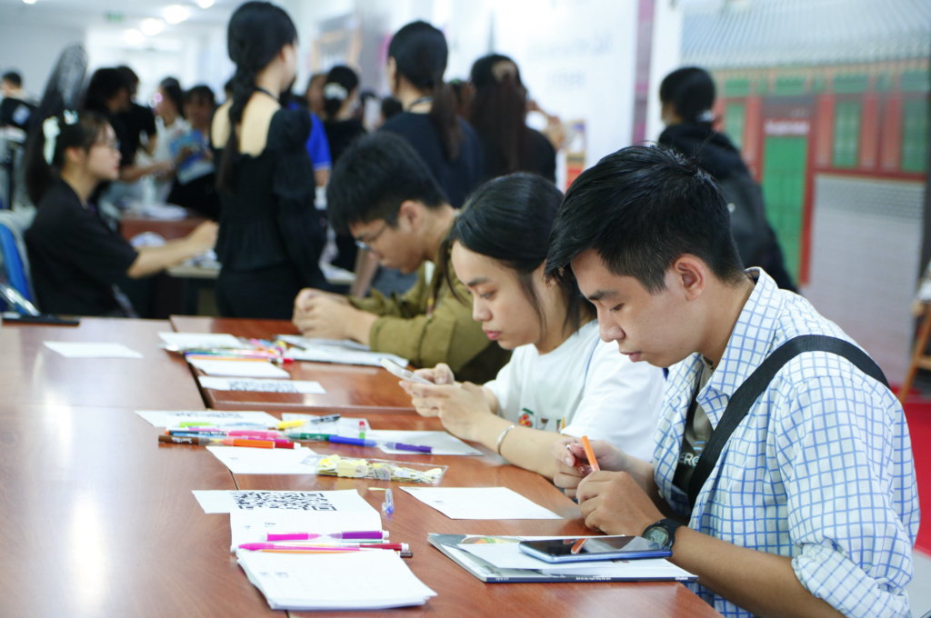 Sinh viên trải nghiệm tự tay vẽ móc khóa - Ảnh: Thanh Thúy