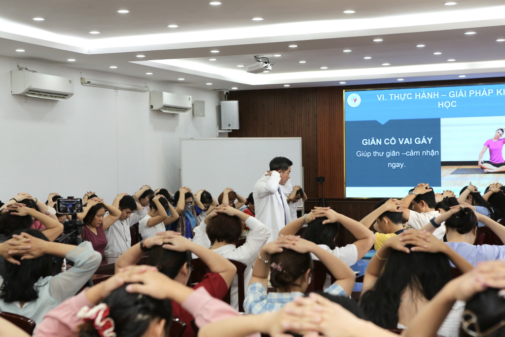 Bác sĩ Đinh Văn Thành hướng dẫn người tham dự chương trình thực hiện bài tập - Ảnh: NGHI CHÂU