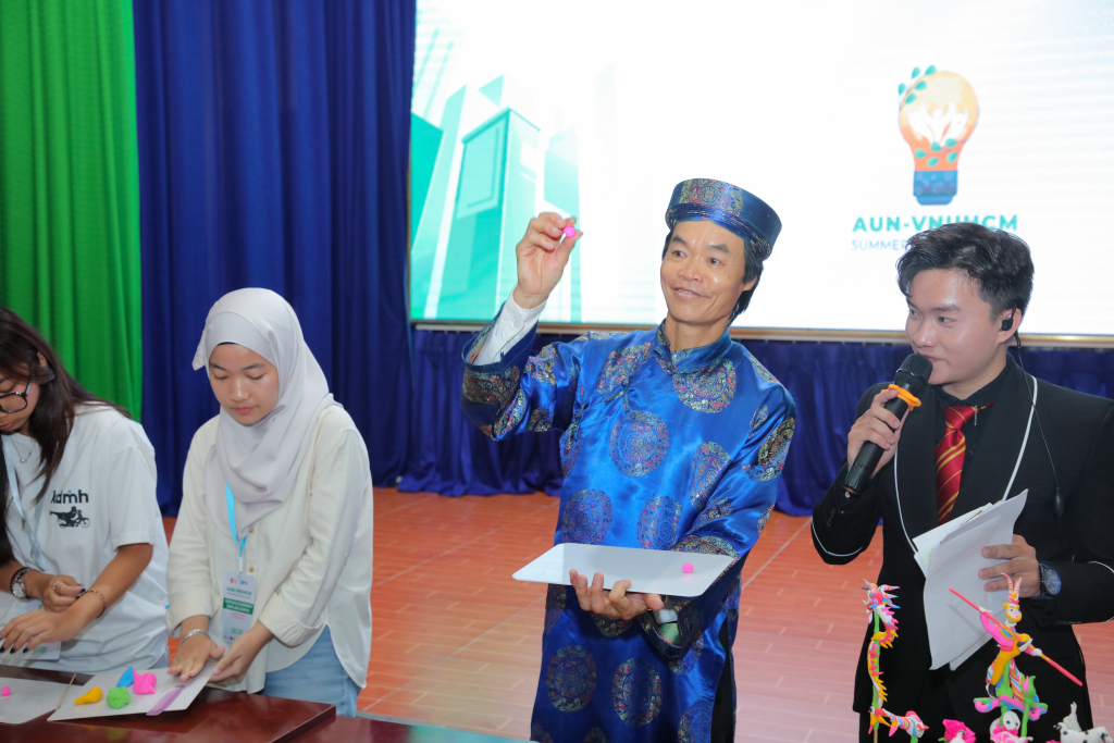 Nghệ nhân Phạm Tiến Hiền hướng dẫn các bạn sinh viên làm tò hè hình hoa hồng - Ảnh: LÝ NGUYÊN