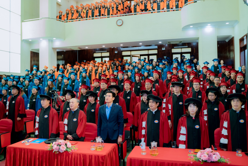 Toàn thể đại biểu, thầy cô và các tân Tiến sĩ, Thạc sĩ, Cử nhân thực hiện nghi thức chào cờ - Ảnh: Công tác Sinh viên